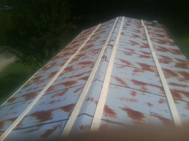 Rusted metal roof panels with new wood purlins before replacement — Storm Damage Roof Repair in Nicktown by Roofing Brothers