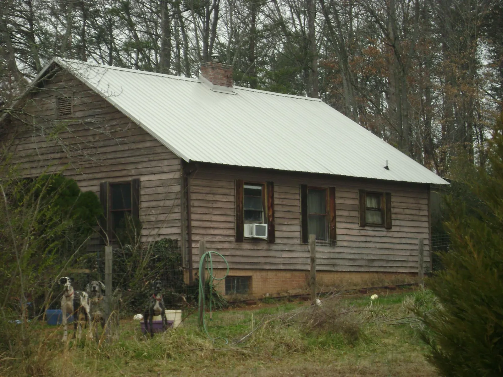 White metal roof on an old wood sided farmhouse, from a Metal Roof Installation job in Nicktown